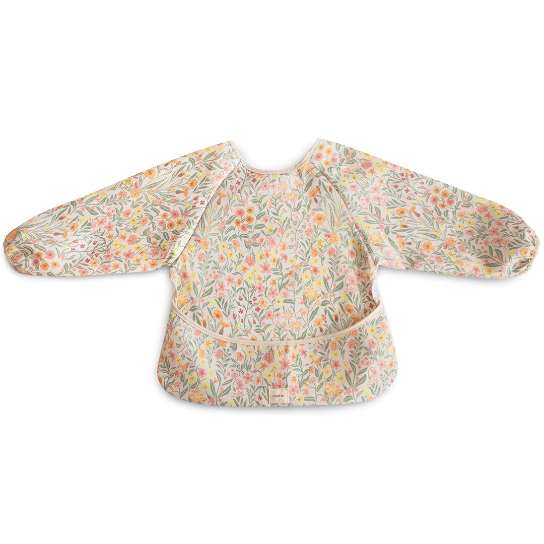Mushie mouwslab voor baby's met een pastel bloemenpatroon, plat op een witte achtergrond.