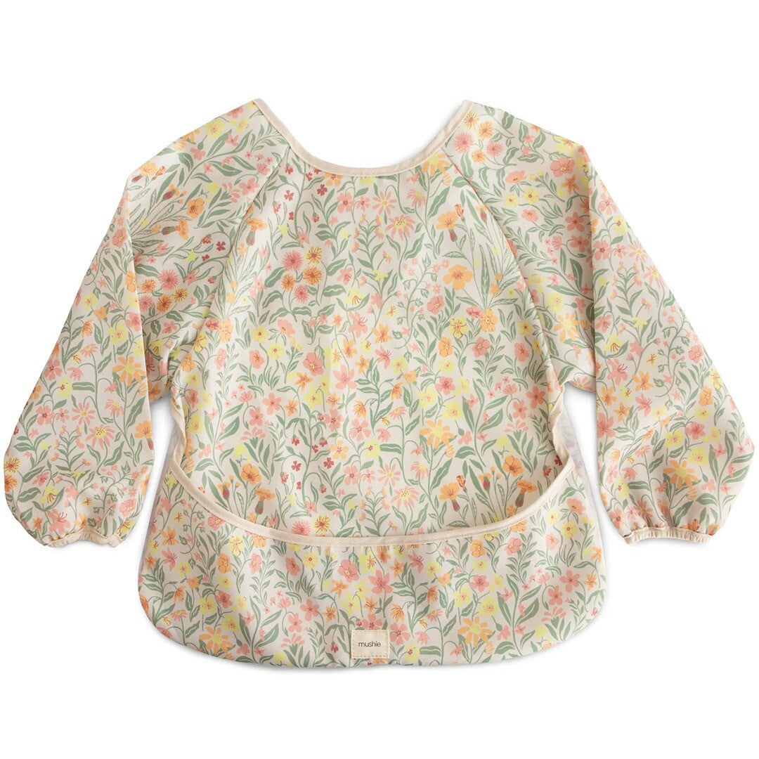 Mushie mouwslab voor baby's met een pastel bloemenpatroon, plat op een lichte achtergrond.