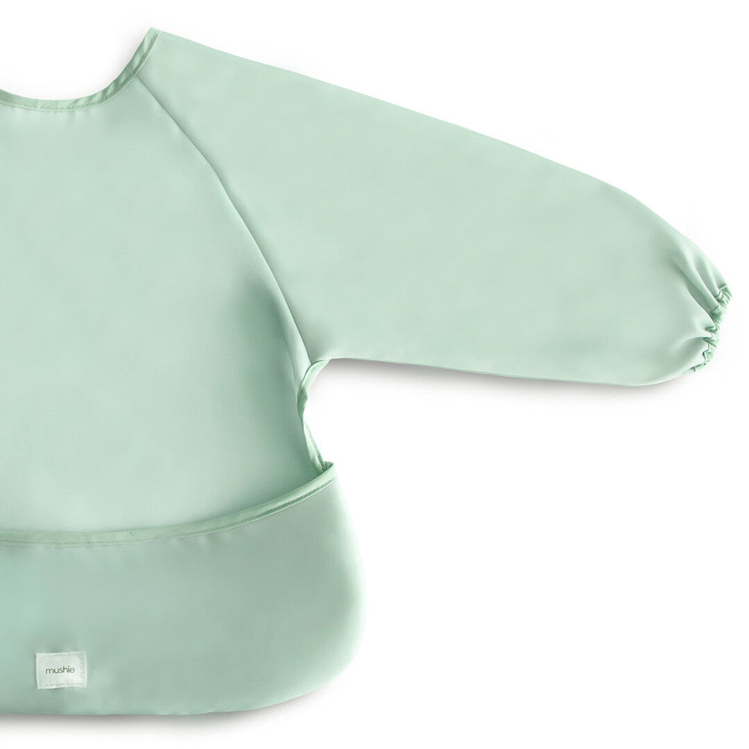 Detailopname van de mushie mouwslab in effen groen, met het merklabel zichtbaar.