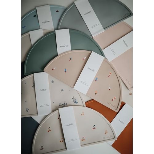 Een overzicht van meerdere Mushie placemats in verschillende kleuren en met diverse patronen.