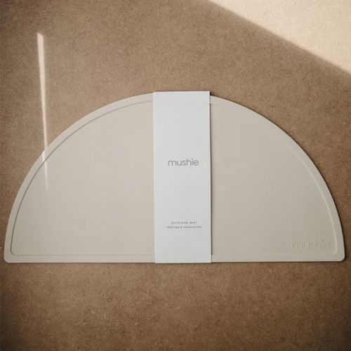 Verpakking van de Mushie siliconen baby placemat in zandkleur.