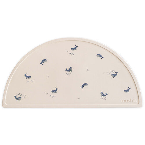 Mushie beige siliconen placemat voor baby's met blauwe walvissen.