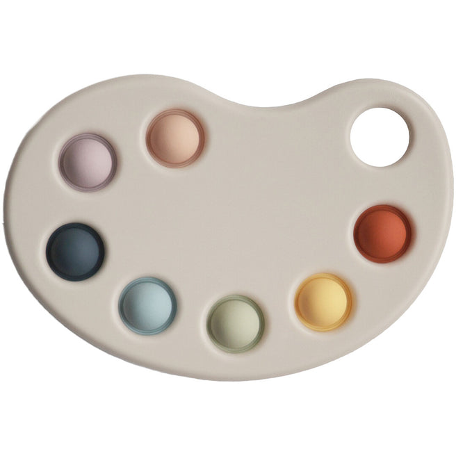 Mushie sensorisch verfpalet babyspeelgoed met zeven gekleurde pop-it bubbels.