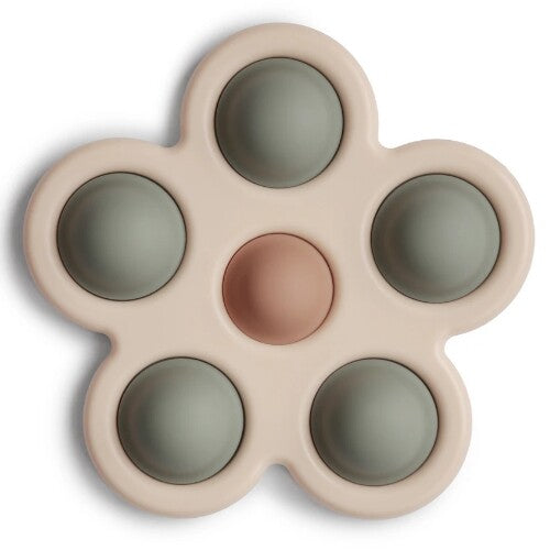 Mushie sensorische bloem babyspeelgoed in beige met groene en roze siliconen bubbels.