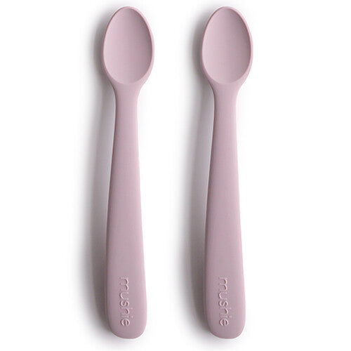 Twee mushie siliconen babylepels in zacht lila op een witte achtergrond.