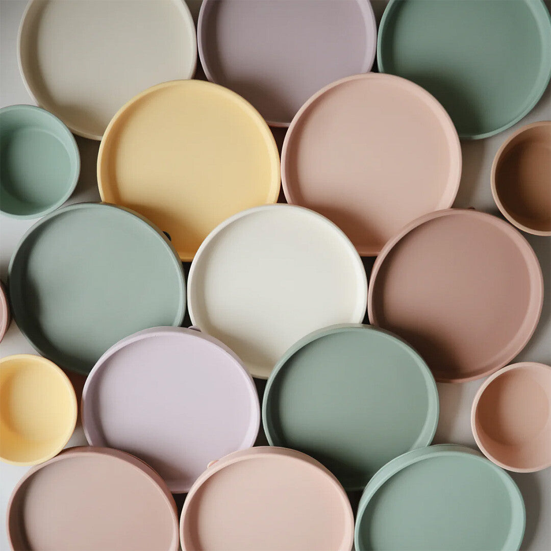 Een collectie mushie siliconen voederborden en kommen in diverse pastelkleuren.