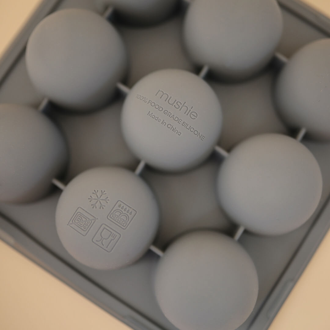 Detailopname van een grijze mushie siliconen invriesvorm met de merknaam en productinformatie in reliëf.