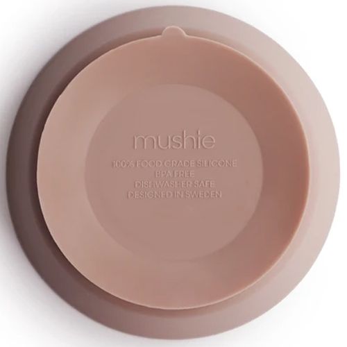De onderkant van een Mushie siliconen kinderkom met zuignap en merklogo.
