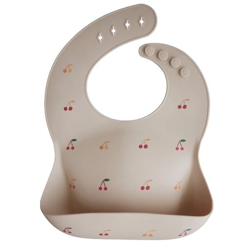 Mushie siliconen babyslab in beige met kersenpatroon.