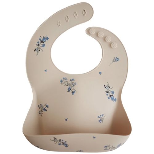 mushie siliconen slabbetje in beige met blauwe bloemenprint en opvangbakje.