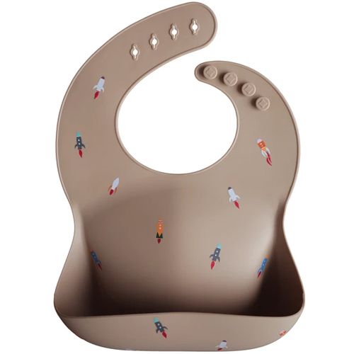 Mushie siliconen slabbetje in beige met raketpatroon.