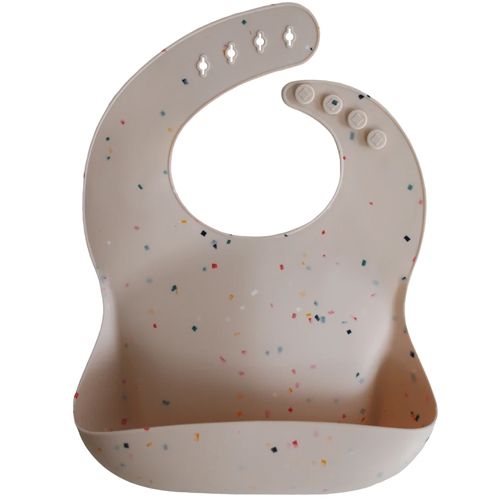 Mushie siliconen babyslab in beige met kleurrijke confetti stippen.