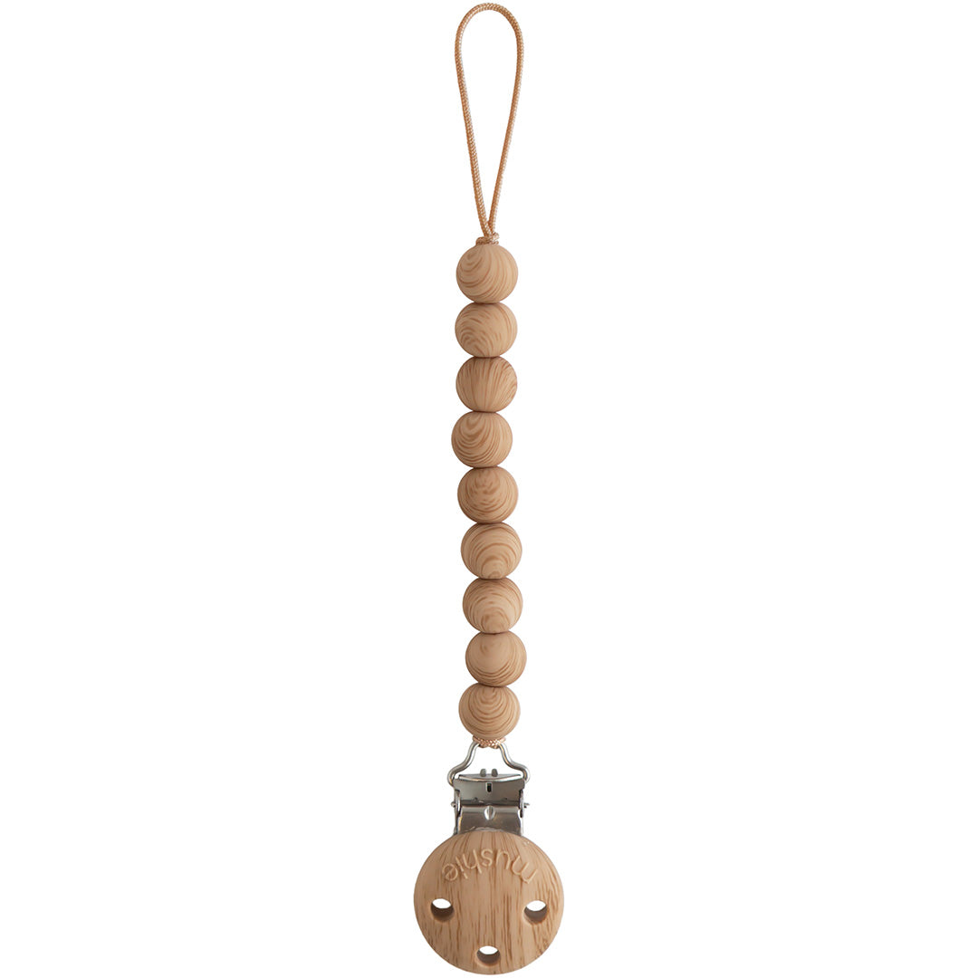Mushie speenkoord met houten kralen en een ronde houten clip op een witte achtergrond.