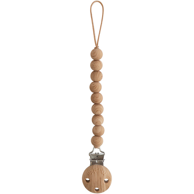 Mushie speenkoord met houten kralen en een ronde houten clip op een witte achtergrond.