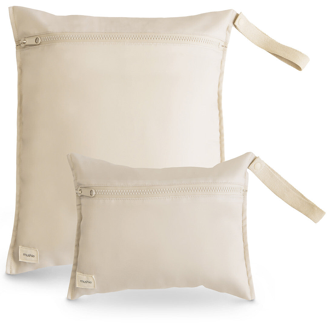 Twee mushie waterdichte opbergzakken in beige, een grote en een kleine, schuin op een witte achtergrond.