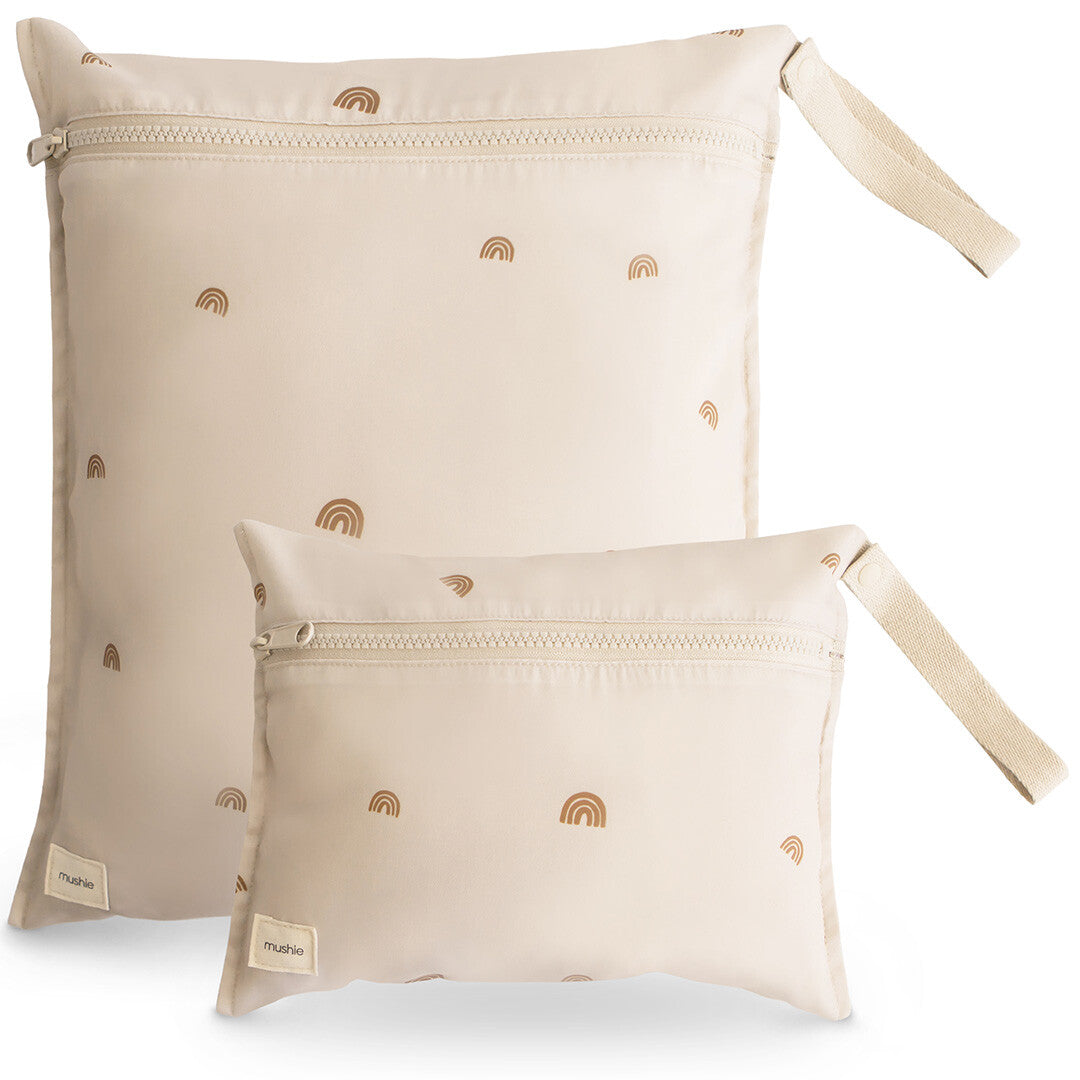 Twee mushie waterproof opbergzakken in beige met regenboogpatroon, schuin gefotografeerd.