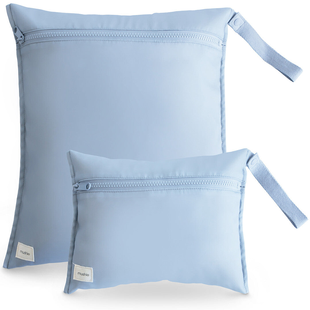 Twee lichtblauwe mushie waterproof opbergzakken, een grote en een kleine, met ritsen en lussen.