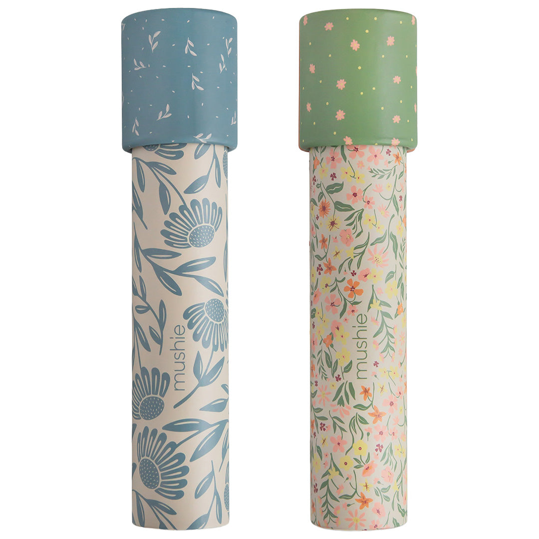 Twee Mushie kaleidoscopen met bloemenpatronen, één blauw en één groen.