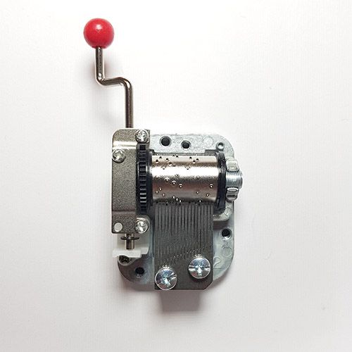Kinderboeken zilveren muziekdoosje mechanisme met rode hendel op een witte achtergrond.