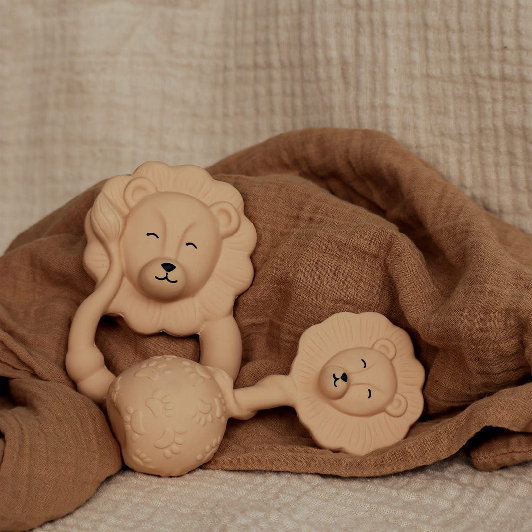 Twee natruba beige leeuw bijtspeeltjes liggen op een bruine doek.