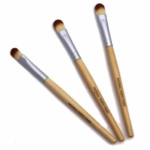 Drie Natural Earth Paint ecologische verfkwastjes met bamboe handvatten en beige borstels, schuin op een witte achtergrond.