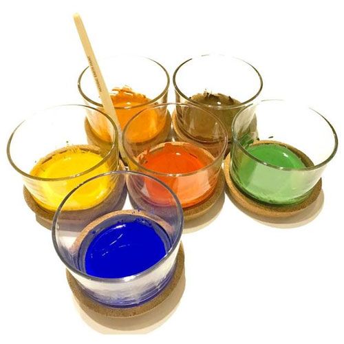 Zes glazen met gemengde Natural Earth Paint in verschillende kleuren en een roerstaafje.