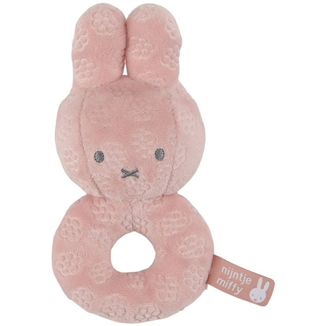 Nijntje-miffy roze rammelaar in de vorm van Nijntje met een bloemenpatroon.