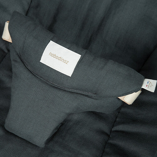 Detail van de veiligheidsgordel van het groenblauwe nobodinoz babywipstoeltje met merklabel.