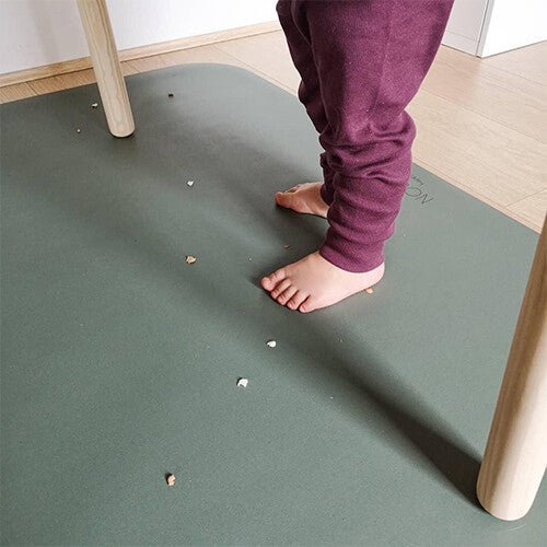 Noui noui knoeimat met blote kindervoeten en verspreide kruimels.