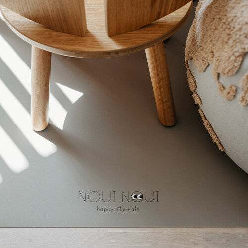 Detail van de Noui Noui knoeimat op de vloer met houten stoelpoten.