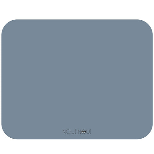 Noui noui placemat in effen dusty blue met afgeronde hoeken en logo.