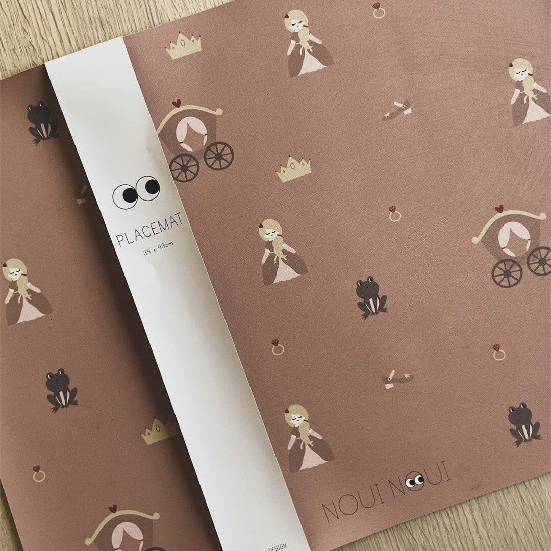 De Noui Noui placemat met prinsessenpatroon, opgerold met de productverpakking.