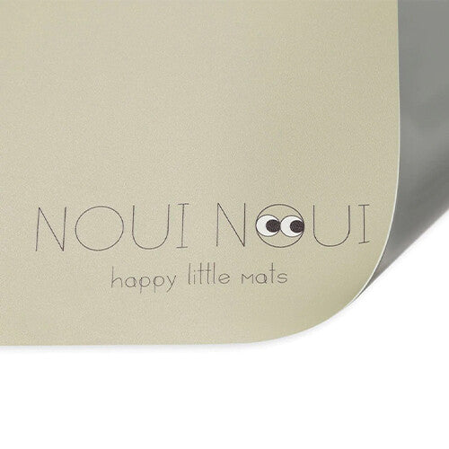 Detail van de Noui Noui beige placemat met logo en tekst 'happy little mats'.