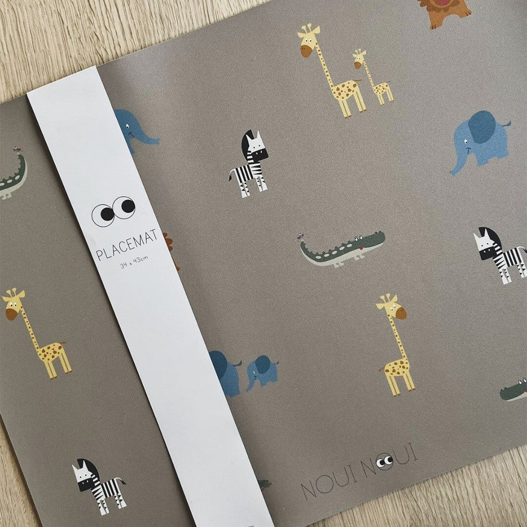 Noui Noui placemat met safari dierenpatroon en een witte verpakkingsband met de tekst 'PLACEMAT'.