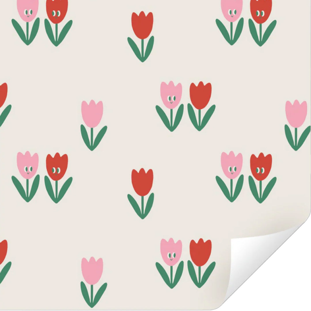 ole inpakpapier met een patroon van rode en roze tulpen op een beige achtergrond, met een licht opgerolde hoek.