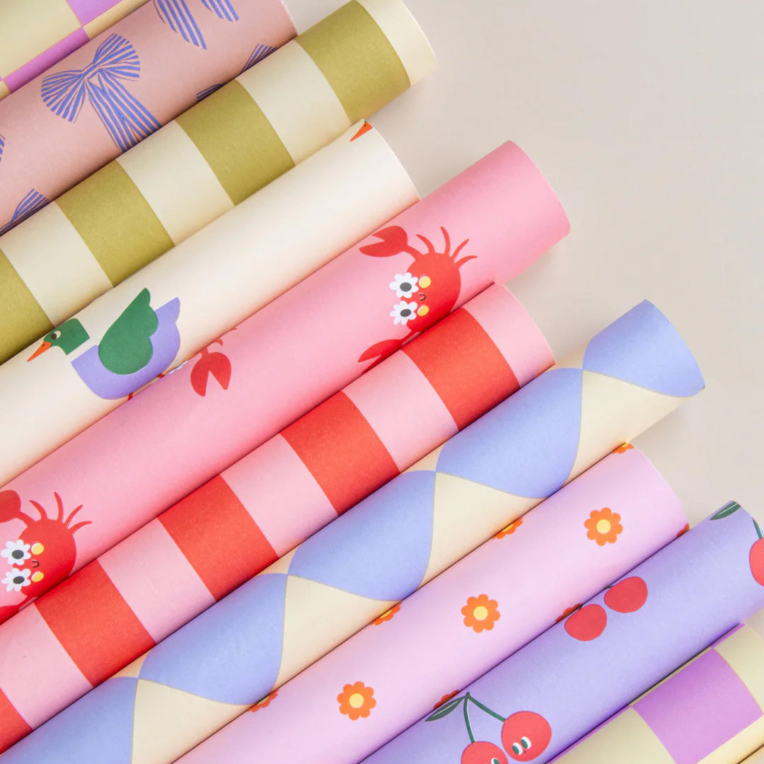 Collectie ole inpakpapierrollen met diverse patronen, waaronder ruiten, strepen en dieren.