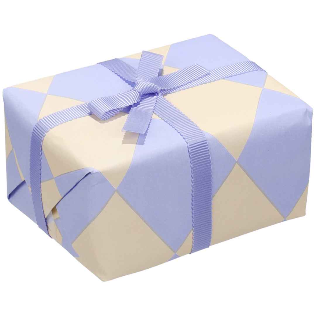 Een cadeau ingepakt met ole inpakpapier met vanille en ijsblauwe ruiten en een lichtblauw lint.