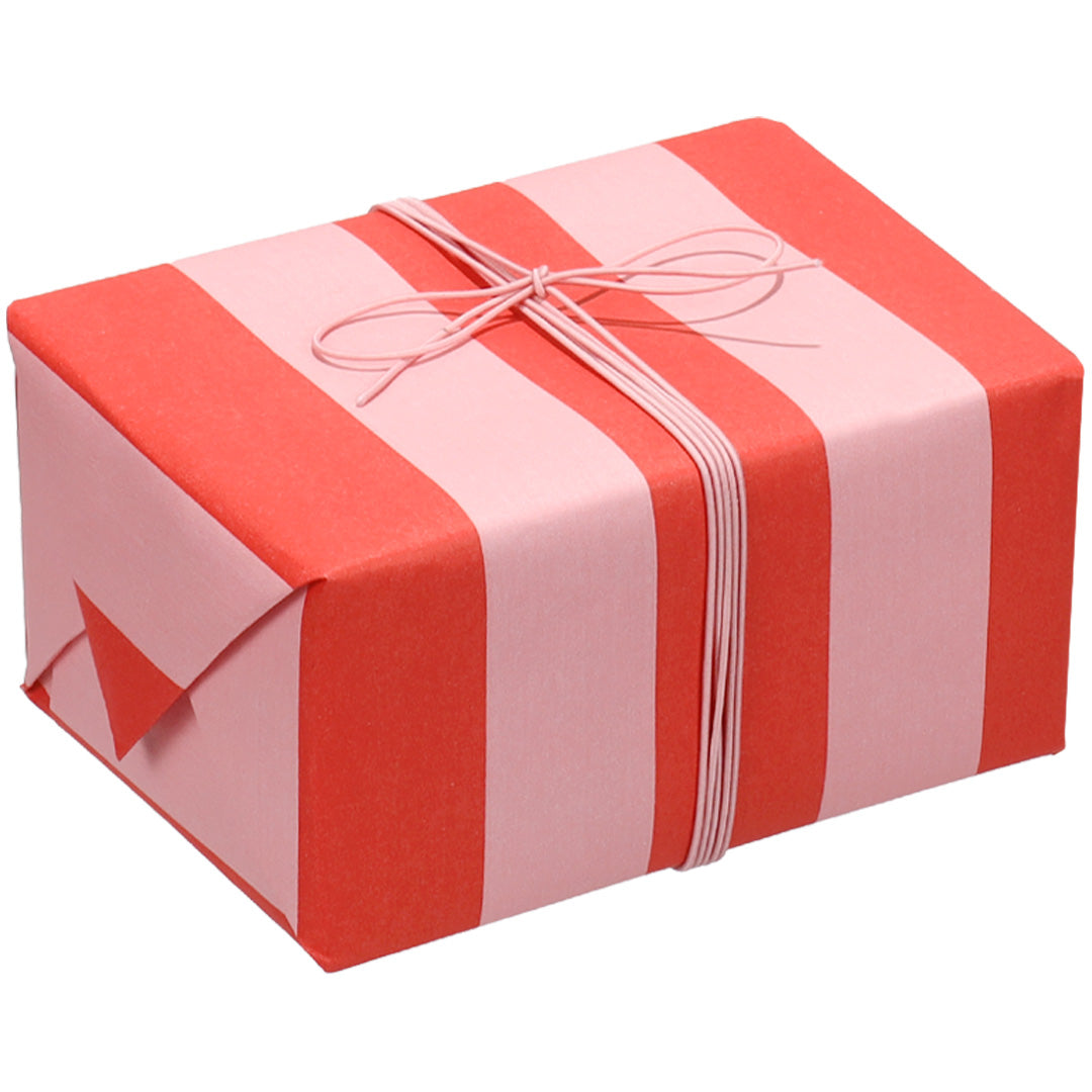 Een ingepakt cadeau met ole inpakpapier met rood-roze strepen en roze touw.