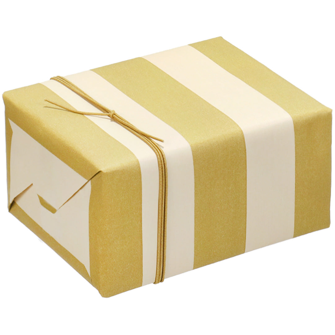 Een cadeau ingepakt met ole gestreept inpakpapier in vanille en zeewierkleur, vastgebonden met een touwtje.