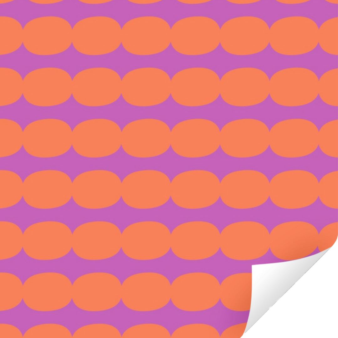 Ole inpakpapier met een patroon van oranje ovale vormen op een paarse achtergrond, met een opgerolde hoek.