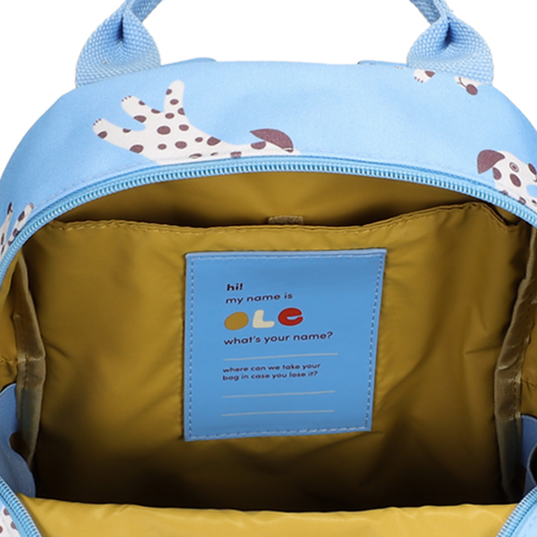 Detail van de open Ole peuterrugzak met een geel interieur en een blauw naamlabel.