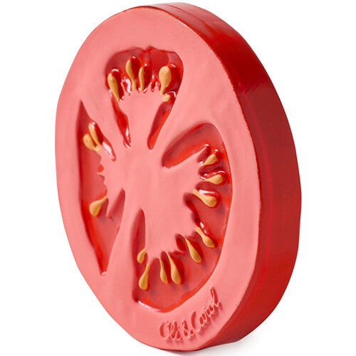 Schuin aanzicht van het oli & carol bijtspeelgoed in de vorm van een rode tomatenschijf.