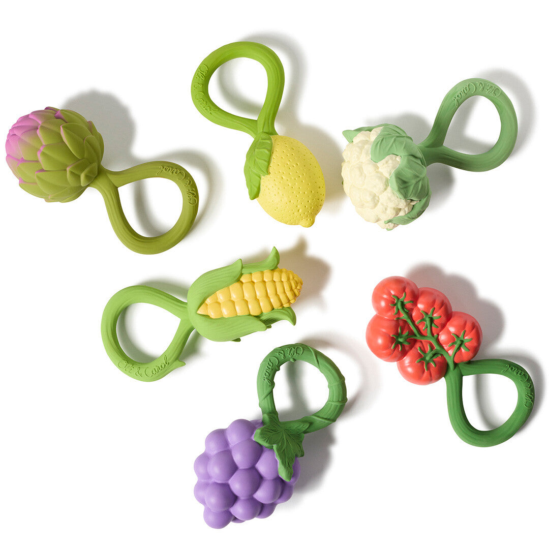 Een collectie van zes Oli & Carol babyspeelgoed rammelaars in de vorm van fruit en groenten.