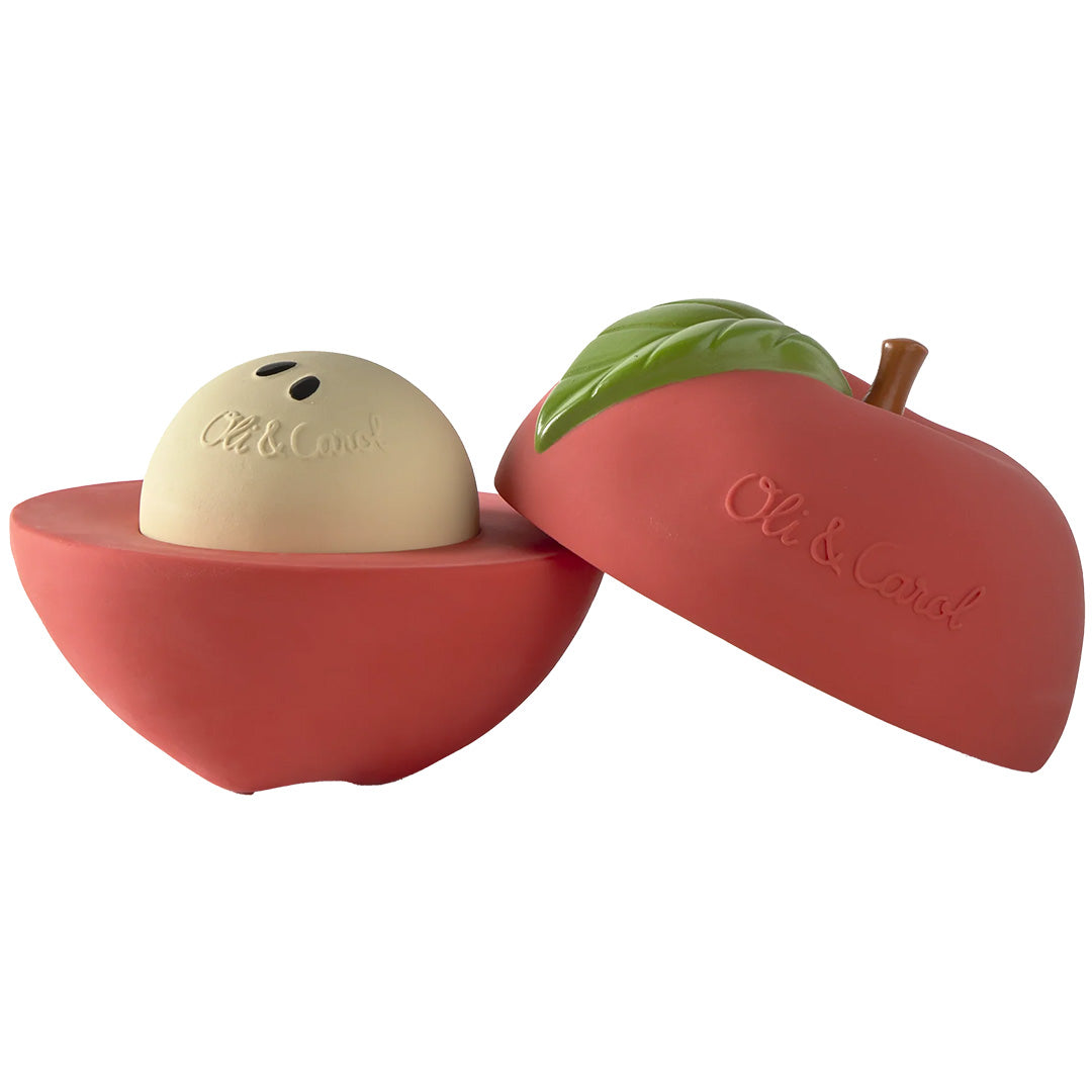 Oli & Carol 3-in-1 babyspeelbal in de vorm van een rode appel, opengemaakt met de crèmekleurige rammelaar zichtbaar.