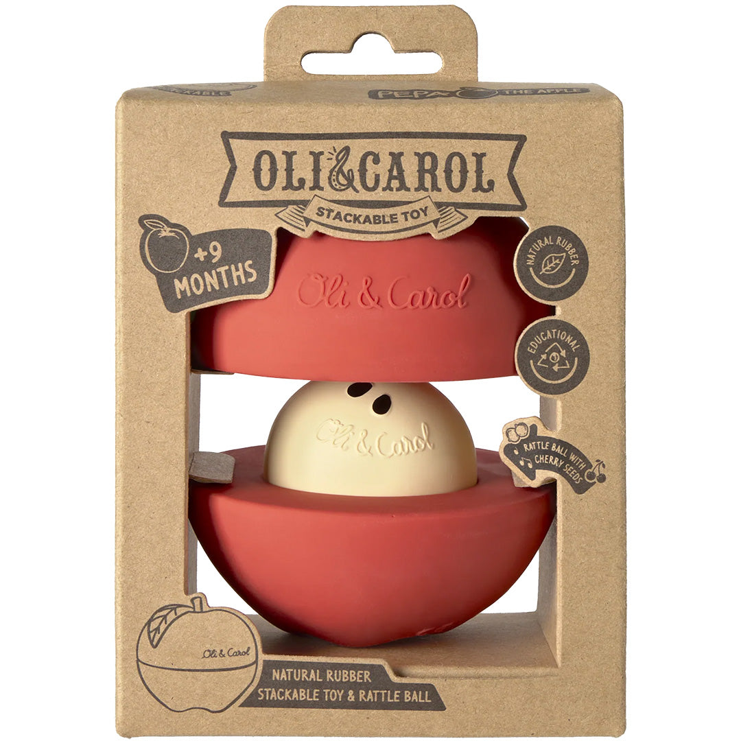 De verpakking van de Oli & Carol 3-in-1 babyspeelbal, een bruine kartonnen doos met de rode appel zichtbaar door een uitsparing.