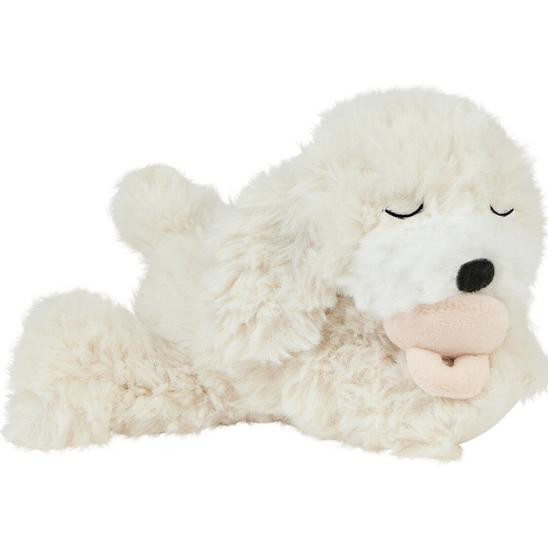 Olli Ella pluchen knuffelhond Dinkum Puppy Belle in crème, liggend op zijn zij met gesloten ogen en tong uit.
