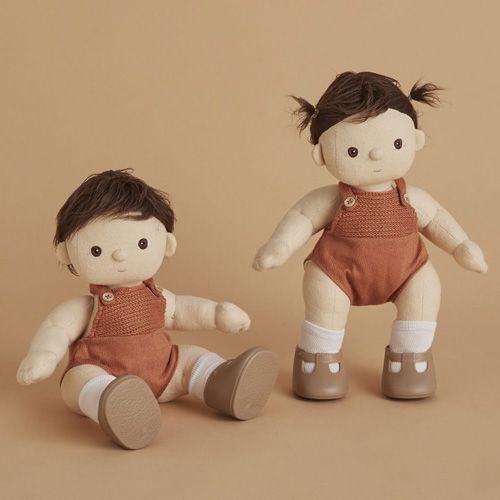 Twee Olli Ella lappenpoppen Dinkum Dolls met bruin haar, een zittend en een staand, beide met roestkleurige rompers en bruine schoenen.