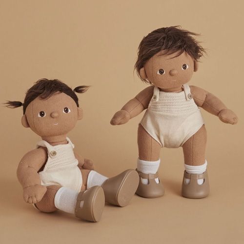 Twee Olli Ella lappenpoppen Dinkum Dolls met bruin haar, één zittend en één staand, beide in crèmekleurige rompertjes.