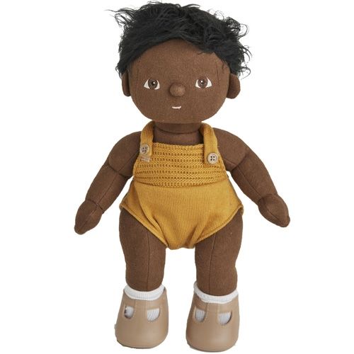 Olli Ella lappenpop jongen met donkere huid en zwart haar, staand in een geel gebreid rompertje.