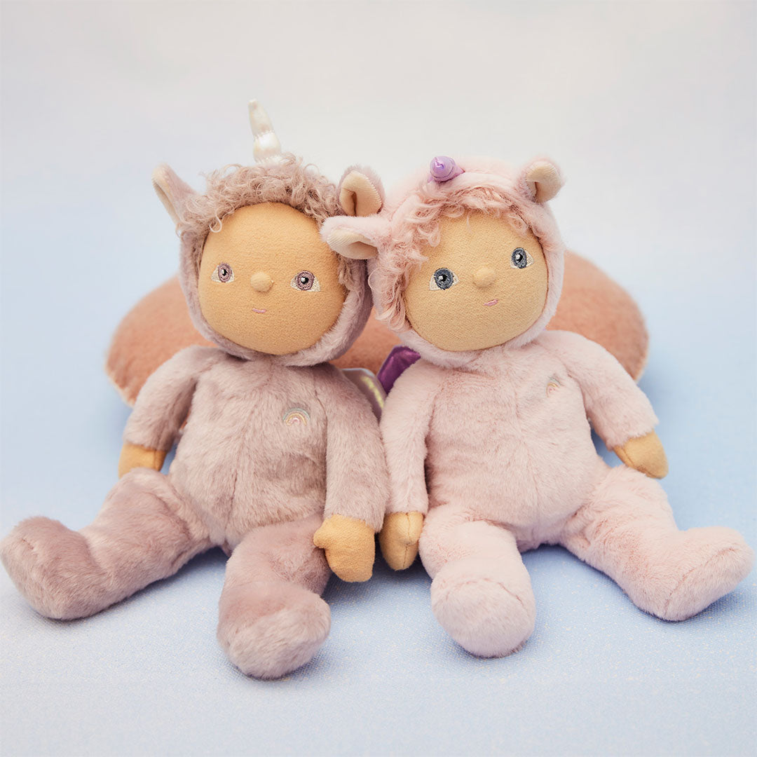 Twee olli ella dinky dinkum lappenpoppen, een paarse Uma Unicorn en een roze, zitten naast elkaar.